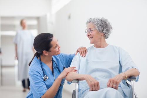 Elderly patient looking at a nurse in hospital.