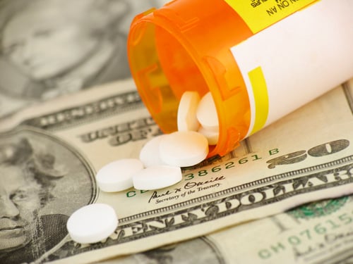 Prescription drug pills poured on top of money