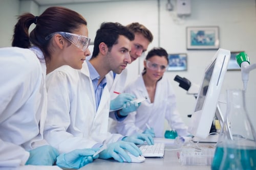 Side view of serious researchers looking at computer screen in the laboratory