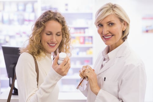 Smiling pharmacist and customer discussing a product in the pharmacy