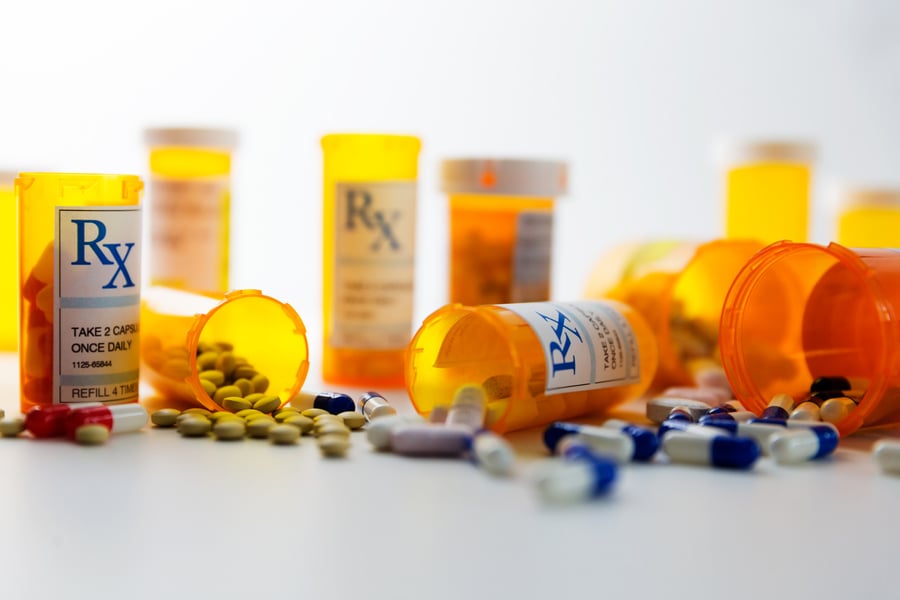 pill bottles with prescription drugs spilling out on a table