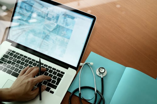 Top view of doctor hand working with modern computer and smart phone 